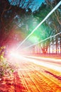 Automobile light traces passing through at a unpaved farm road s