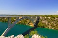 Automobile long high arched bridge over the Krka river in Croatia near Sibenik. Picturesque Croatian river landscape in Royalty Free Stock Photo