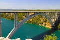 Automobile long high arched bridge over the Krka river in Croatia near Sibenik. Picturesque Croatian river landscape in Royalty Free Stock Photo