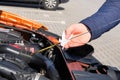 Automobile maintenance concept. Driver checking oil level in car engine dipstick. Close up Royalty Free Stock Photo