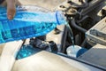 Automobile maintenance. Filling the windshield washer fluid on a car. Pouring antifreeze liquid for washing car screen Royalty Free Stock Photo