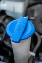 Automobile Maintenance. Windshield washer fluid cap with blue color in the engine room of car Royalty Free Stock Photo