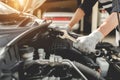 Automobile mechanic repairman hands repairing a car engine automotive workshop .