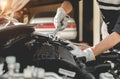 Automobile mechanic repairman hands repairing a car engine automotive workshop.