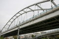 Automobile overpass over the railway tracks in the city with a semicircular arch above it.