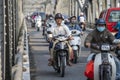 Automobile and pedestrian steel bridge over the river in Hue town, Vietnam. People on motorbikes on the road across the bridge Royalty Free Stock Photo