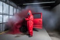 automobile repairman painter hand in protective glove with airbrush pulverizer painting car body in paint chamber