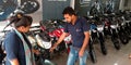 automobile sales staff presenting latest motorcycle at bajaj showroom in India