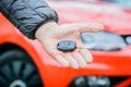 Automobile Seller - Men holding car key in front of red modern car Royalty Free Stock Photo