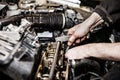 Automobile service worker or garage mechanic repairing auto car engine Royalty Free Stock Photo