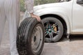 Automotive mechanic man carrying spare tire preparing change a wheel of car. Auto repair service.