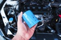 Automotive motor oil filter holds in auto mechanic hand with a car engine compartment on background Royalty Free Stock Photo