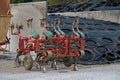 Automotive part of an agricultural plow next to worn out tires storage Royalty Free Stock Photo