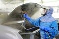 An auto body is spray painted by a worker on a production line in the paint shop. Royalty Free Stock Photo