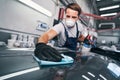 Hard-working male cleaning car in auto repair shop