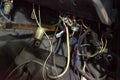 Automotive wiring under the wheel of an old russian retro car, a disassembled dashboard and seats for repairing and connecting