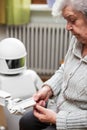 Autonomous caregiver robot is holding medication container or pill box