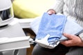 Autonomous caregiver robot is holding two towels, giving them to an senior adult woman in her living room