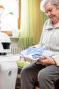 Autonomous caregiver robot is holding two towels, giving them to an senior adult