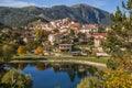 Autumn in Abruzzo: panoramic view of Villalago medieval village with blue lake and foliage