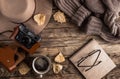 Autumn accessories flat lay. Hat, brown sweater, notebook, cup of coffee, eyeglasses, retro camera