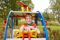 In autumn afternoon, boy plays on playground