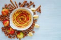 Autumn apple tart in the baking dish decorated with fresh apples, hazelnuts and spices - anise, cinnamon on the gray kitchen table Royalty Free Stock Photo