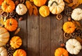 Autumn arch frame of pumpkins and natural fall decor on a rustic dark wood background