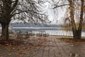 Autumn atmosphere of abandoned benches under bushy trees and white birch by the dam