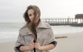 Autumn autdoor brunette woman portrait, woman dressed in knitted sweater posing against sea Royalty Free Stock Photo