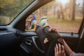 Autumn, Auto travel. Cose-up of a woman during the road trip in a car. Woman feet in warm socks on car dashboard.