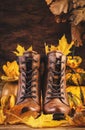 Autumn background with brown leather boots, pumpkins, maple and oak leaves on rustic wood background,. Country style female Royalty Free Stock Photo