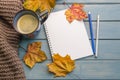 Composition with autumn leaves, blank notebooks, a cup of coffee on a blue wooden table Royalty Free Stock Photo