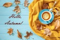 Autumn background concept - blue cup of black tea with lemon slice and honey on a yellow scarf, dried leaves and text Hello, Autum Royalty Free Stock Photo