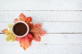 Autumn background with dry leaves and hot cup of coffee on white wooden table, copy space. Top view Royalty Free Stock Photo