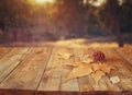 Autumn background of fallen leaves over wooden table and forest backgrond with lens flare and sunset