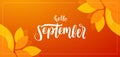 Autumn background with handwritten lettering of Hello September with fall leaves on orange background Royalty Free Stock Photo