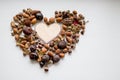 Autumn background with heart, chestnuts, nuts, peanuts, acorn, on white background with copy space. Love in Fall concept