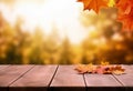 Autumn background with maple leaves on wooden table and bokeh sunlight shine.