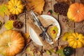 Autumn background with plate, fall leaves and pumpkin over wooden table. Royalty Free Stock Photo