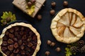 Autumn background with present box, oak leaves, acorns, pines and fruit galette pies Royalty Free Stock Photo