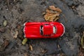 Autumn background. Red retro car on road from above. Red car moving on autumn road in dark forest. Fall scene. Toy red Royalty Free Stock Photo