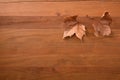 Autumn background with two dry brown leaves on wooden