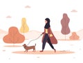 Autumn background. Young arab woman in hijab walks with dog through the woods. Concept happy girl in brown coat with