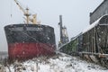 Autumn bad weather, snow, loading coal into the holds of industrial ships in the seaport Royalty Free Stock Photo