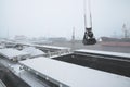 Autumn bad weather, snow, loading coal into the holds of industrial ships in the seaport Royalty Free Stock Photo