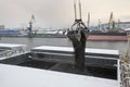 Autumn bad weather, snow, loading coal into the holds of industrial ships in the seaport Royalty Free Stock Photo