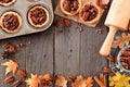 Autumn baking scene frame with pecan tarts over wood