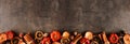 Autumn baking spices and ingredients bottom border on a dark banner background