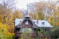 Autumn beatiful house in forest with colorful leaves and trees.